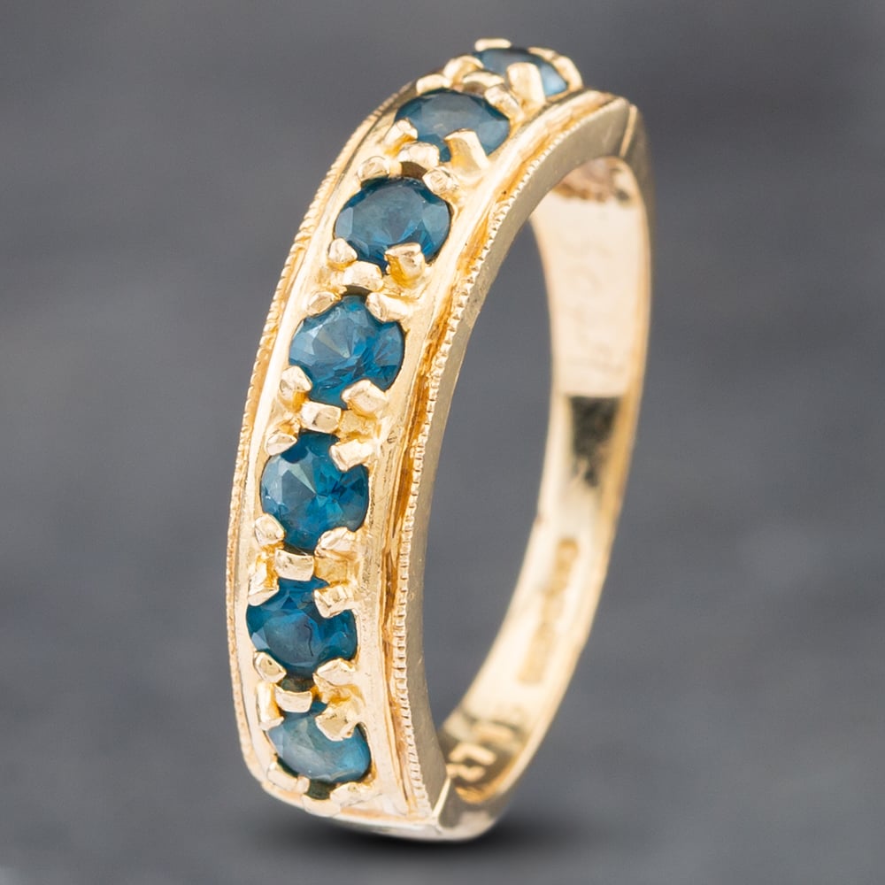 Product photograph of Pre-owned 9ct Yellow Gold Blue Topaz 7 Stone Half Eternity Ring 41102462 from The Jewel Hut