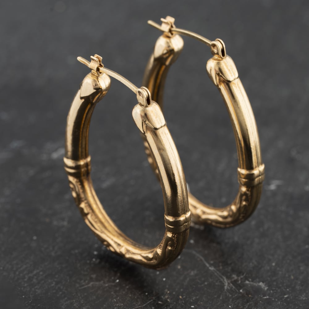 Click to view product details and reviews for Pre Owned Yellow Gold 31mm Swirl Pattern Oval Creole Earrings 41173420.