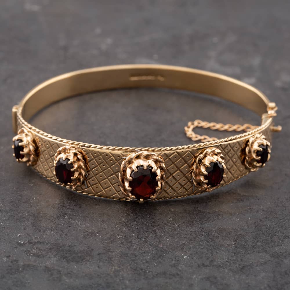 Product photograph of Pre-owned Vintage 9ct Yellow Gold Garnet Five Stone Standard Hinged Bangle 41211073 from The Jewel Hut