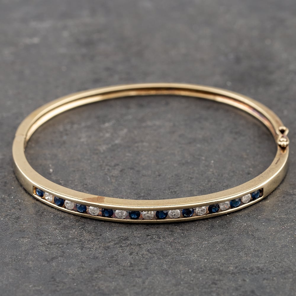 Product photograph of Pre-owned 9ct Yellow Gold Sapphire Amp Diamond Channel Set Standard Hinged Bangle 41211215 from The Jewel Hut