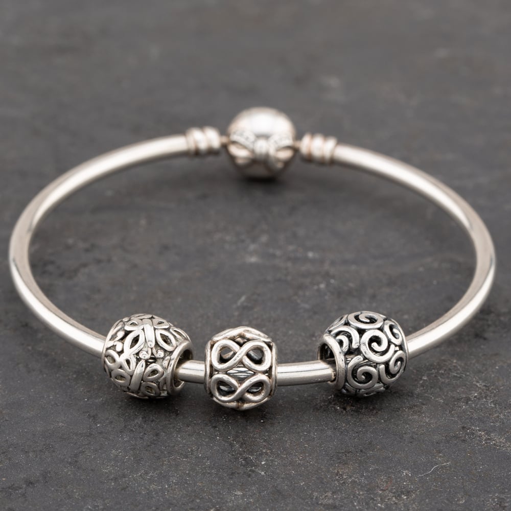 Product photograph of Pre-owned Pandora Silver Pandora Bow Clasp With Three Open Work Beads Standard Charm Bangle 41221371 from The Jewel Hut