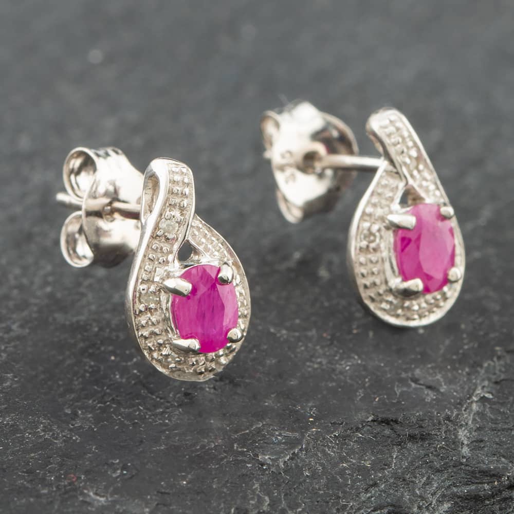 Product photograph of Pre-owned White Gold 0 38ct Oval Cut Ruby Amp 0 03ct Diamond Swirl Stud Earrings 43171089 from The Jewel Hut