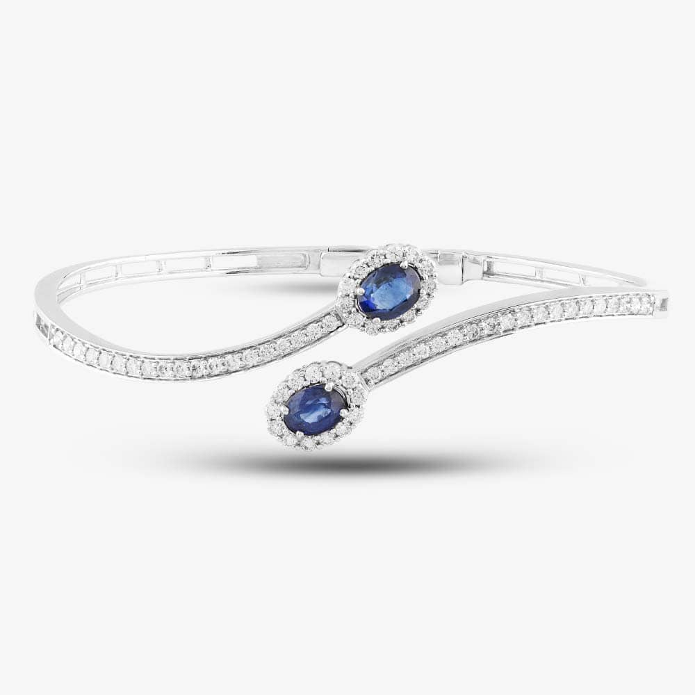 Product photograph of Pre-owned 18ct White Gold 2 19ct Sapphire Amp 1 19ct Brilliant Cut Diamond Double Cluster Cross Over 19cm Hinged Bangle 4321155121 from The Jewel Hut
